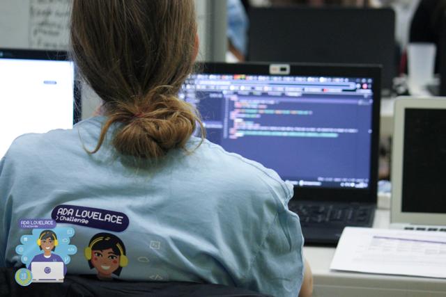 Une participante vue de dos, devant un écran rempli de code