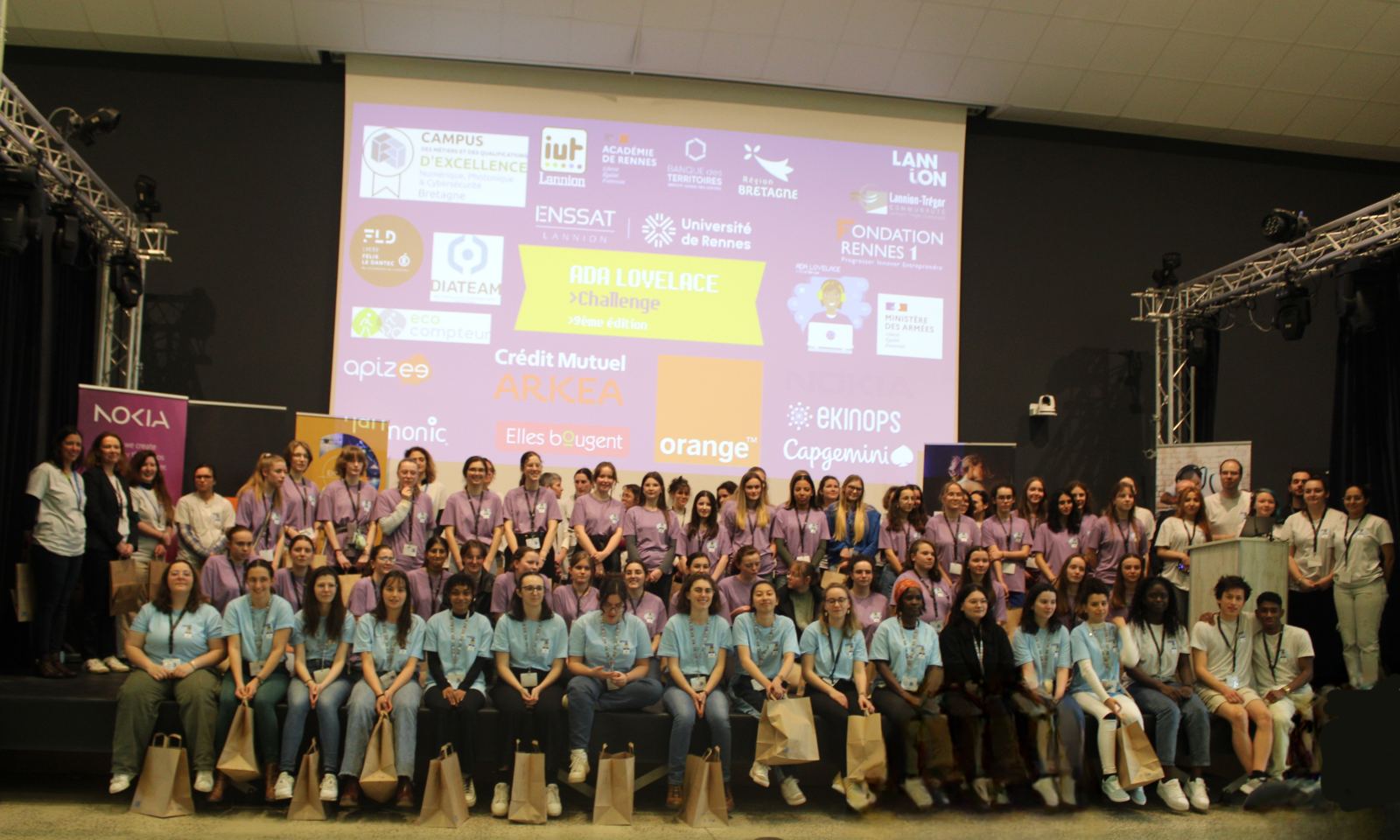 Photo de groupe de l'édition 2024 à Lannion : participantes en T-shirt bleu, tutrices et jurées en violet